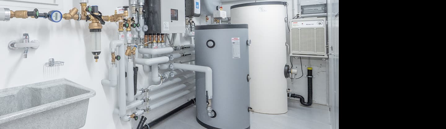 Impianto tecnico con serbatoi cilindrici, tubazioni e strumenti di controllo in una stanza di macchinari industriali.