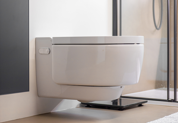 Wc sospeso moderno bianco, installato in bagno con piastrelle chiare e cornice, vista laterale.